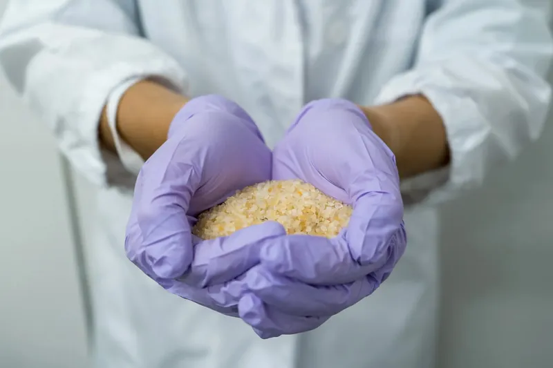 Gloved hands holding EF Polymer granules