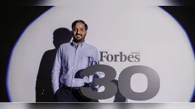 Narayan Lal Gurjar poses in front of the number 30 in the Forbes Japan logo